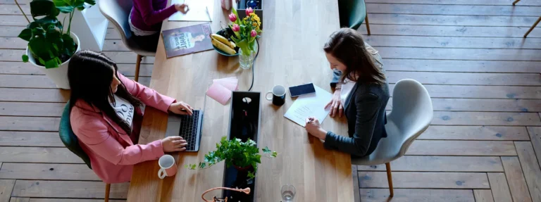 type de configuration de bureau choisir pour favoriser la collaboration - collègues travaillant sur une grande table